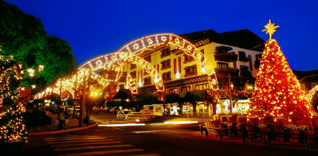 Cidade de Gramado iluminada à noite durante o Natal Luz, com decoração natalina, luzes coloridas e visitantes pelas ruas