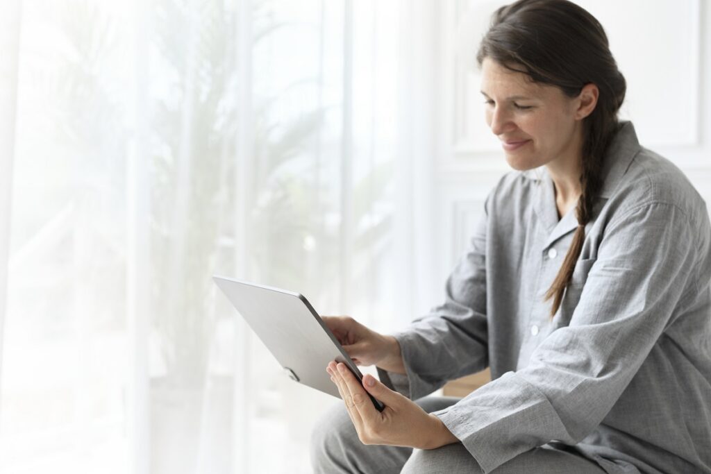 Mulher de pijama em video-chamada em tablet