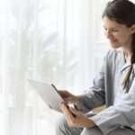 Mulher de pijama em video-chamada em tablet
