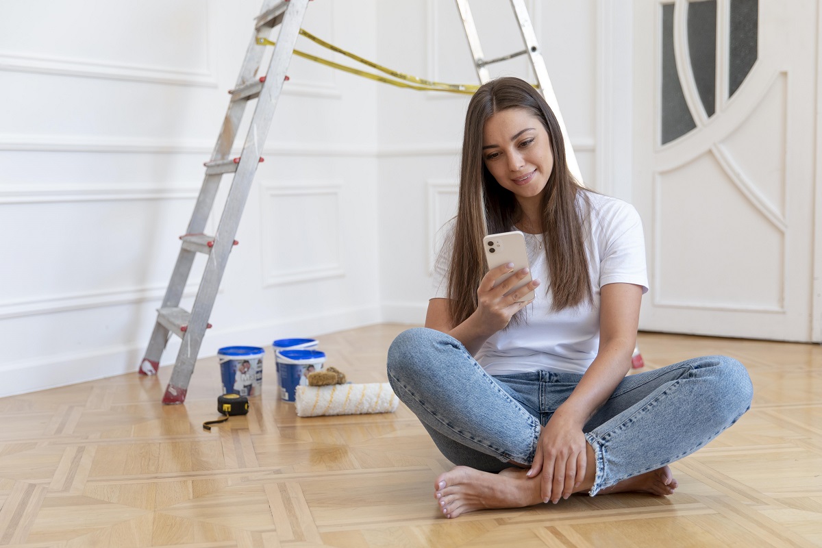 Mulher vendo em celular reformas de apartamento